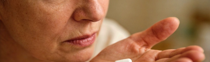 Woman holding medication pill, diuretics and gout connection