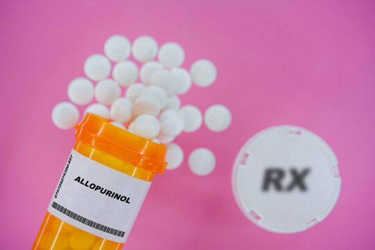 Allopurinol prescription pills scattered around orange pill bottle