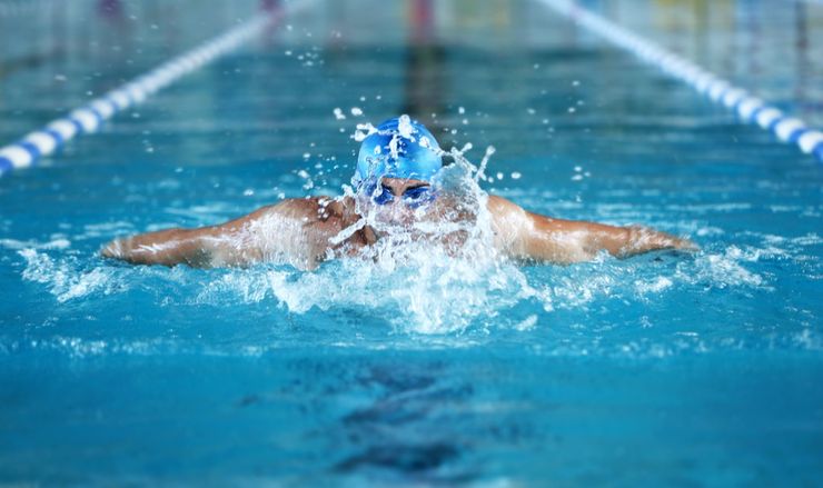 Person swimming laps in a pool, a low-impact exercise recommended for people with gout