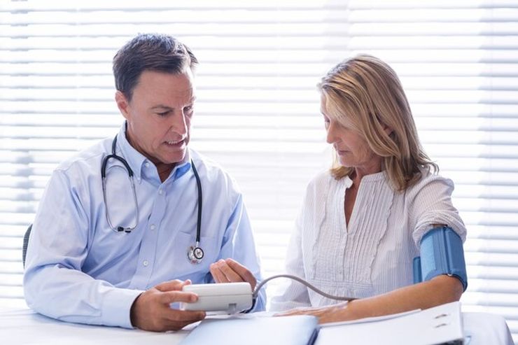 Doctor checking a patient's blood pressure in a clinic during a routine visit