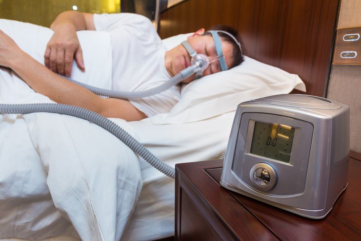 CPAP machine and mask on a bedside table for sleep apnea treatment