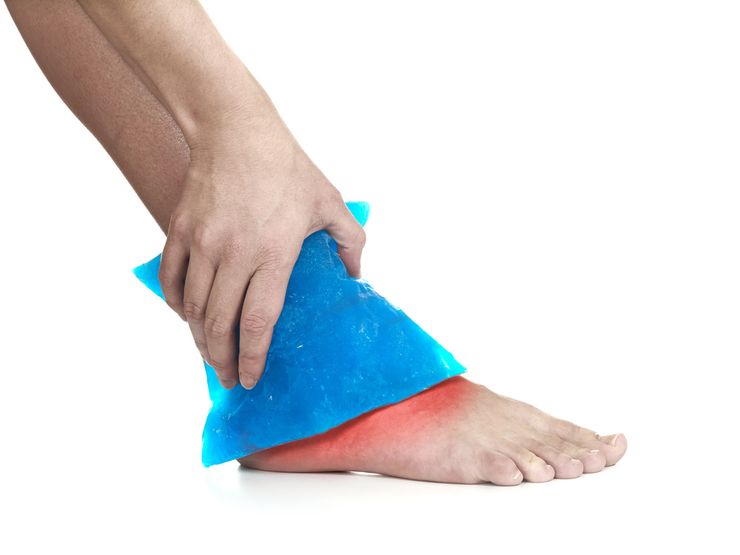 Blue gel ice pack held against a swollen, painful ankle during a gout flare