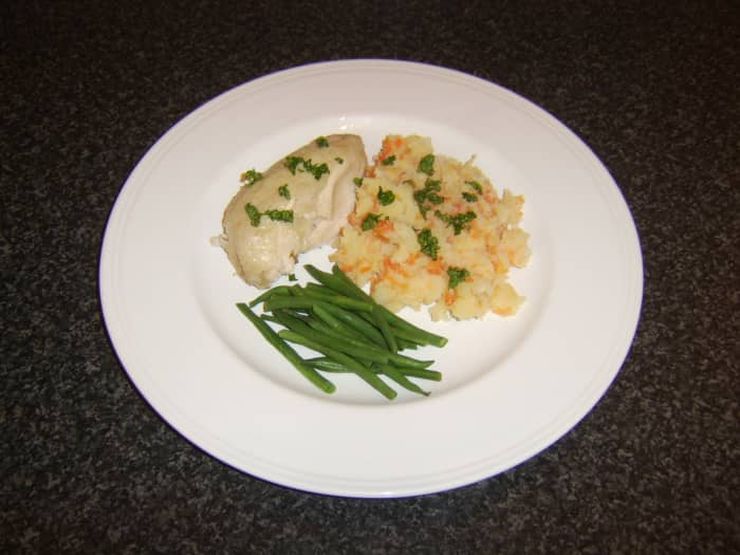 Plate of poached chicken with vegetables and rice