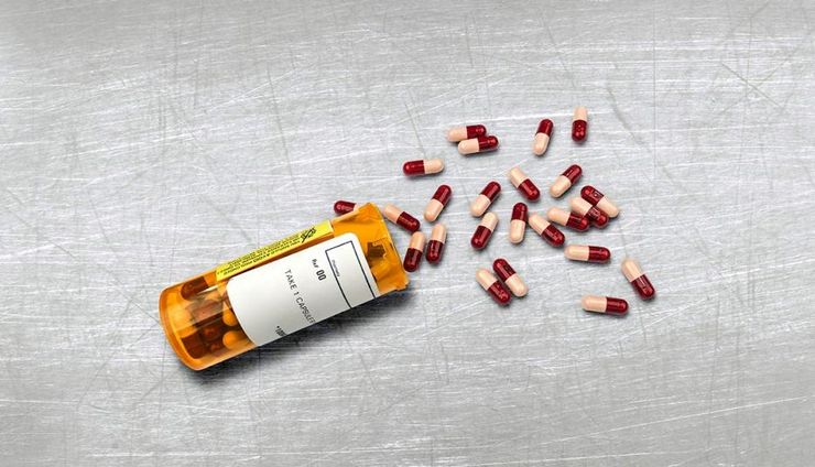 Prescription medication capsules spilling from a pharmacy bottle, the daily treatment that actually works for gout today