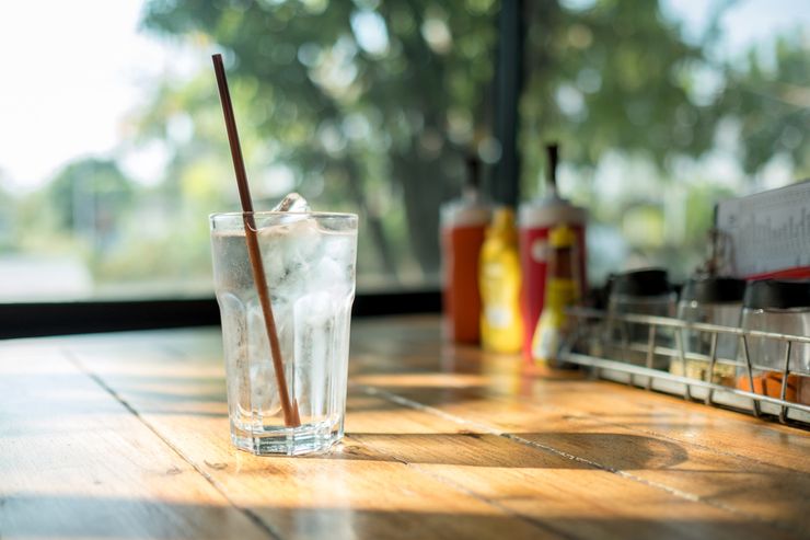 Glass of iced water on a sunlit wooden table as an alternative to alcohol