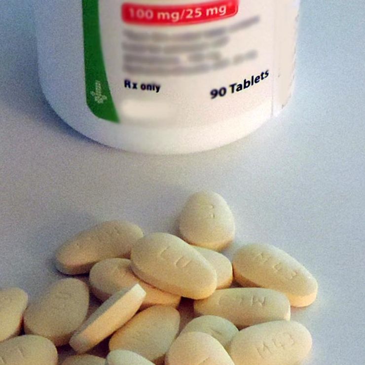 Scattered prescription tablets spilled on a counter next to a medication bottle