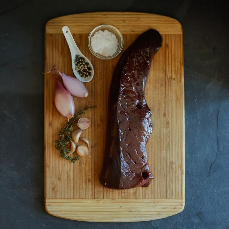 Raw beef liver on a cutting board, a high purine organ meat that people with gout should limit