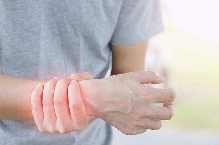 Person holding a painful wrist during a gout flare