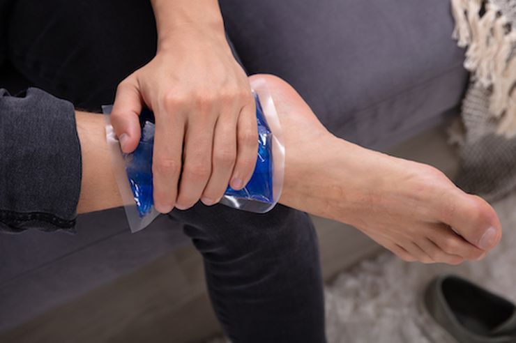 Ice pack being applied to a swollen foot at home after a joint injection