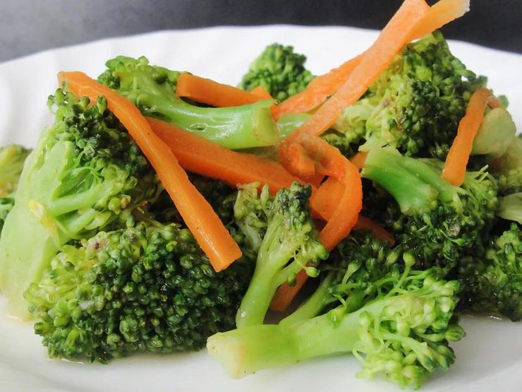 Lightly steamed broccoli and carrots served on a white plate